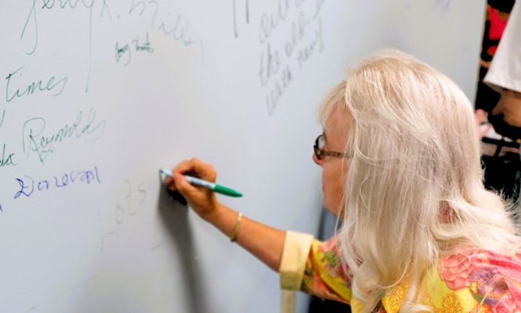 Senior woman writes on a wall
